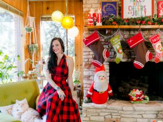 Woman Sits in Living Room Beside Fireplace and Holiday Decor