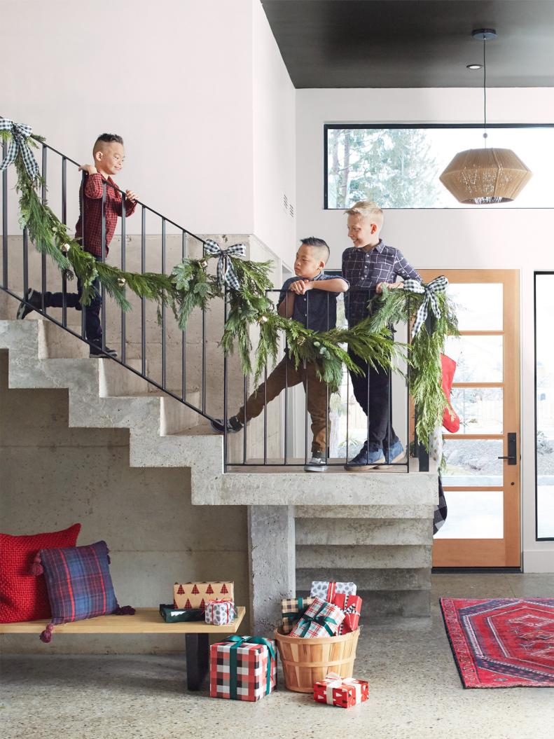 The floating concrete staircase is one of Luke’s favorite features in the house — shout-out to Clint for helping make it structurally sound. It’s spruced up for the holidays with cypress garland and black-and-white bows, while wrapped presents ready to be doled out to extended family do double duty as decor.