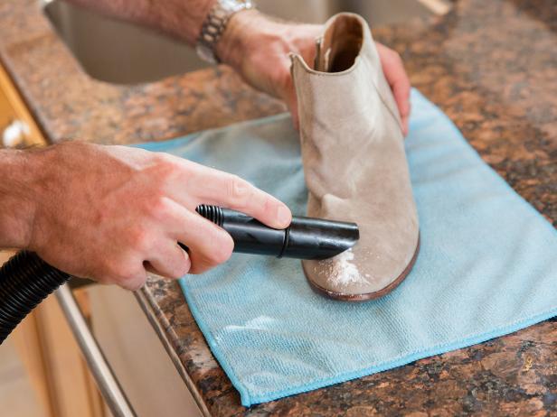 Remove the oily powder without rubbing it into the fabric, either by knocking the dust off or using a vacuum. If the first pass doesn’t remove all the oil, repeat the process with a second application of powder. Once the oil is gone, use a rubber crepe brush to return the suede to its original look.