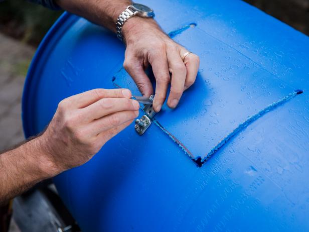 Drill the holes for the bolts and attach each piece of hardware using washers on the inside of the barrel.