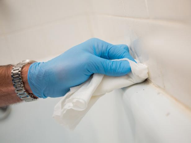 Once you’ve scraped off as much of the old caulk as possible, pour a bit of mineral spirits onto a rag to scrub away the last of the residue.