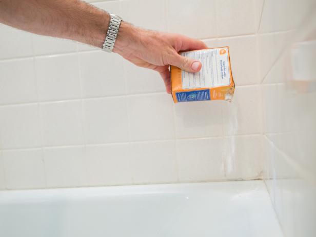If you notice any grime or soap scum where you’ll be re-caulking, wipe the area down with a wet sponge, then sprinkle baking soda over the wet surface.