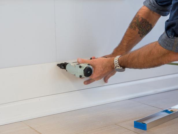 Use a finish nailer to attach the board to the wall at the location of each stud.