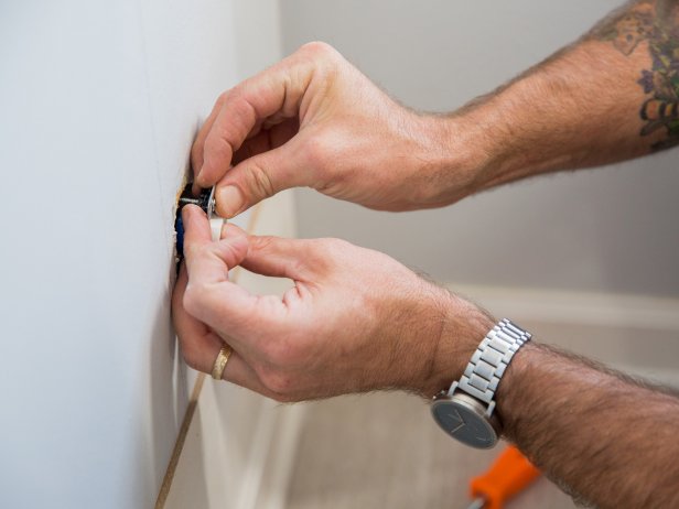 Use a screwdriver to detach your outlet from the box and place one or two washers on the small bolt before reattaching your outlet.