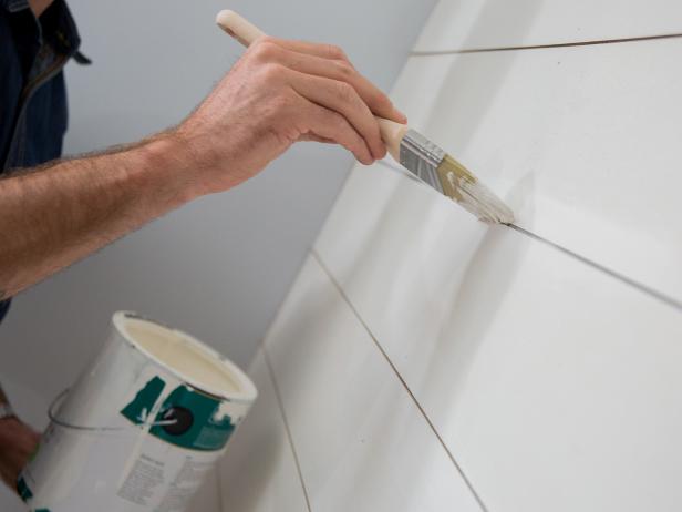 Allow the caulk to dry and then use a trim brush to paint the raw edges of your shiplap boards and cover up any smudges or dried caulk as necessary.