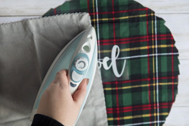 Place the pressing cloth, or a thin tea towel, over the design to avoid scorching or staining the transfer. Press the iron on top of the design for 60 seconds, holding it in one place without moving the iron back and forth.