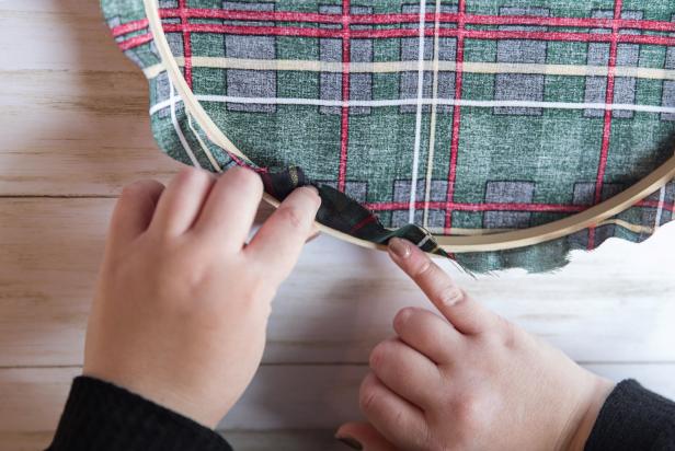 Fold the fabric over the hoop and press into the glue to secure.