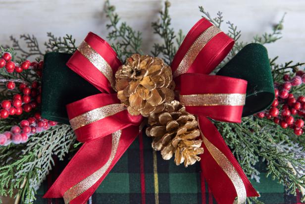 For a festive touch, glue on gilded pinecones in the center of the bow.