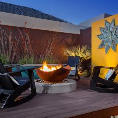 Raised Patio with Rustic Circular Fire Pit and Yellow Wall 