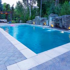 Swimming Pool With Waterfall And Landscape Lighting