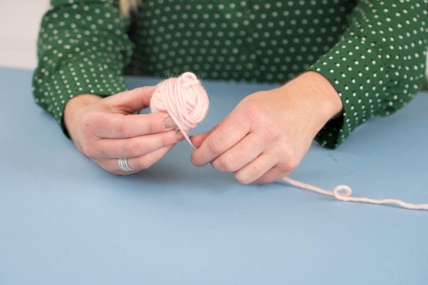 Roll the yarn into a ball by wrapping the string around two fingers and tying a knot to create a small ball. Then continue wrapping. Tuck in the end with a wooden skewer.