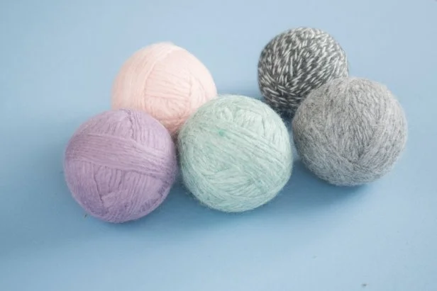 You can use 100 percent wool yarn to make reusable dryer balls that cut down on drying time and soften clothes naturally.