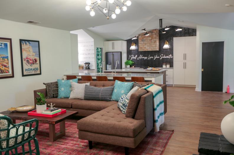 After the renovation, the living room now opens into the much more spacious kitchen, which features a large, functional island, vaulted ceilings, and a customized love message on the backsplash.
