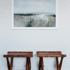 Wood and Leather Folding Stools Below Painting in White Frame