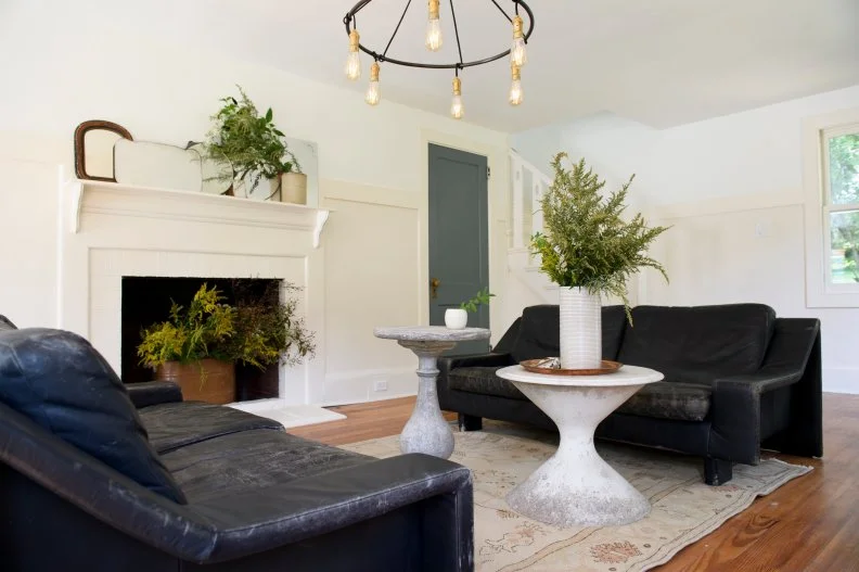 White Living Room with White Fireplace, Black Sofas and Chandelier 