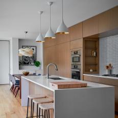 Modern Kitchen and Dining Room With White Pendants