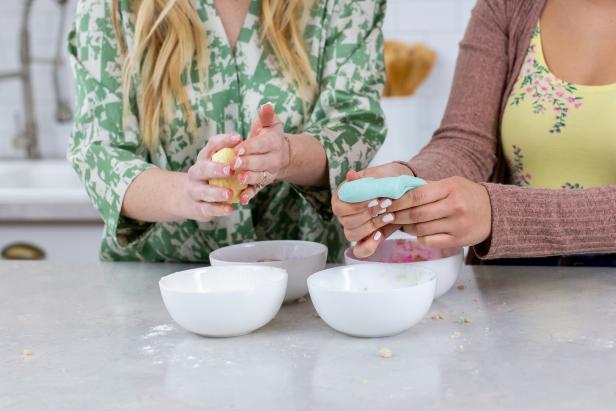 Two Woman Hand-Mixing Melted Peeps Candy Above Bowls