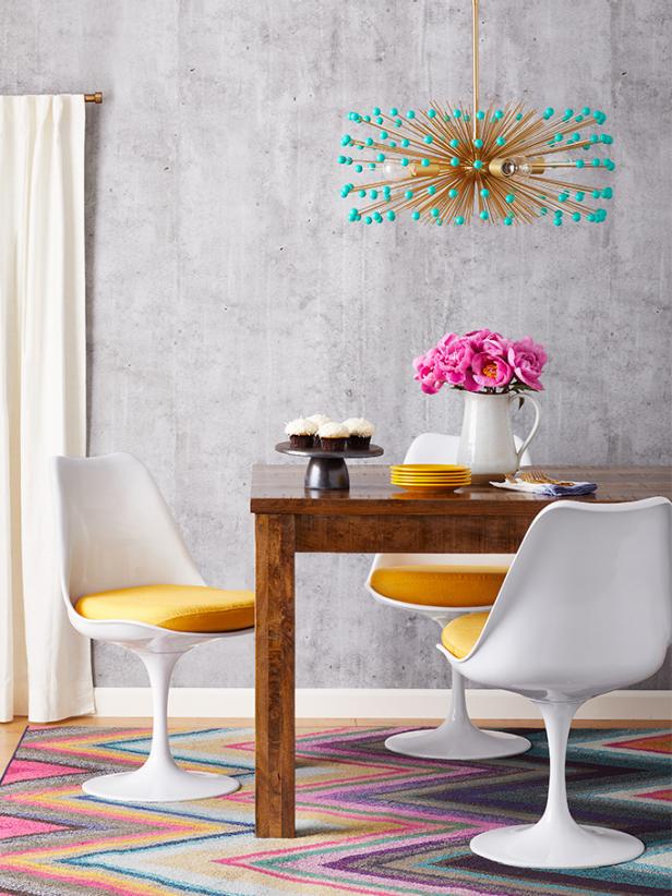 Here's stunning proof from HGTV Magazine that you can pair a farmhouse-style table with mod tulip chairs and a futuristic urchin light.