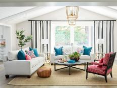 This neutral living room from HGTV Magazine is made lively with pops of color. Vaulted ceiling make the entire room feel more spacious.