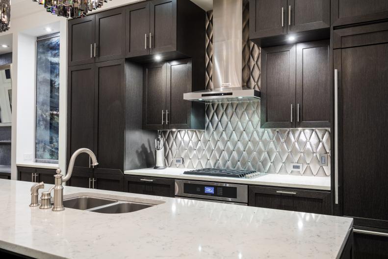 Close Up Of Marble Topped Island And Silver Patterned Backsplash