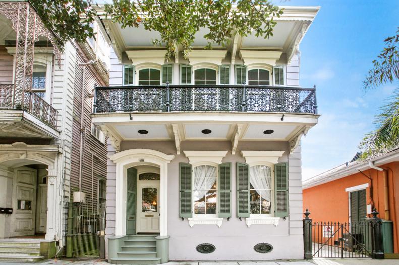 Two-Story Home With Large Overhead Balcony And Iron Railing 