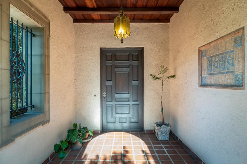 Potted Plants Flank A Heavy Wooden Front Door