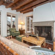 Living Room With Large Fireplace and Exposed Beam Ceiling 