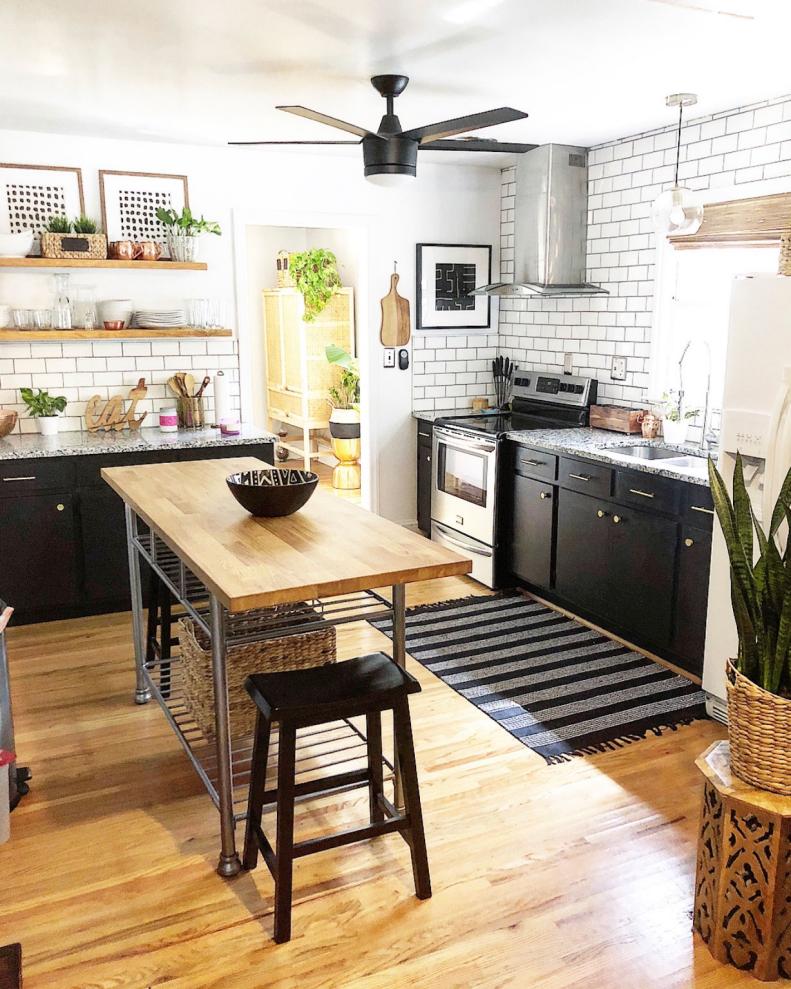 The kitchen is one of the home’s larger spaces and TaLaya and Kerrick took full advantage of the opportunity that afforded. A striped rug stands out against the modern, black cabinetry and plants are sprinkled throughout the kitchen for a touch of greenery. For a modern touch, white subway tile with gray grout creates a stunning kitchen backsplash. 