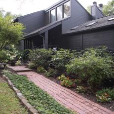 All-Black Cabin Exterior with Brick Walkway 