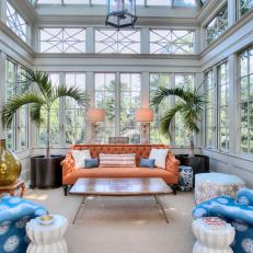 Sunroom Features Tufted Sofa Tucked Between Two Palms