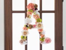 Attach faux flowers to a large chipboard or paper mache letter using hot glue, and hang on your front door.
