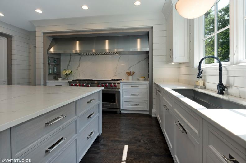 Kitchen with paneling and marble countertop, backsplash and island