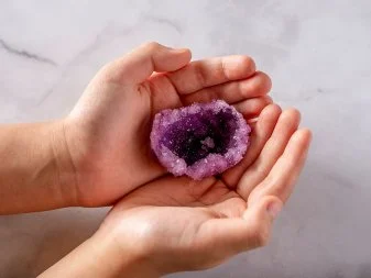 Hands holding an eggshell geode.