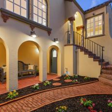 Warm Stucco Home With Landscaped, Brick Walkway