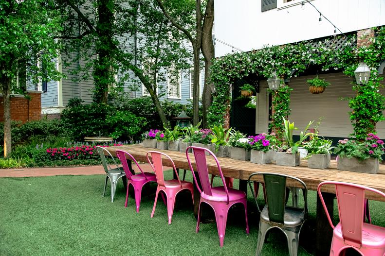 The charming courtyard behind Smithfield Cottage features a trellis adorned with jasmine, a Philippe Starck gnome for a cheeky nod to the garden gnome tradition and a long, communal wooden table where guests can congregate in this private, shady oasis. The Astroturf backyard means lower maintenance and a more sustainable design.