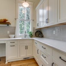 Country Kitchen With White Countertop and Tile Backsplash