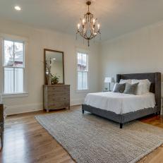 Spacious Bedroom With Chandelier and Upholstered Bed