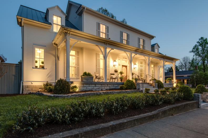 Warm, Welcoming Sconce Lights Illuminate This Expansive Front Porch
