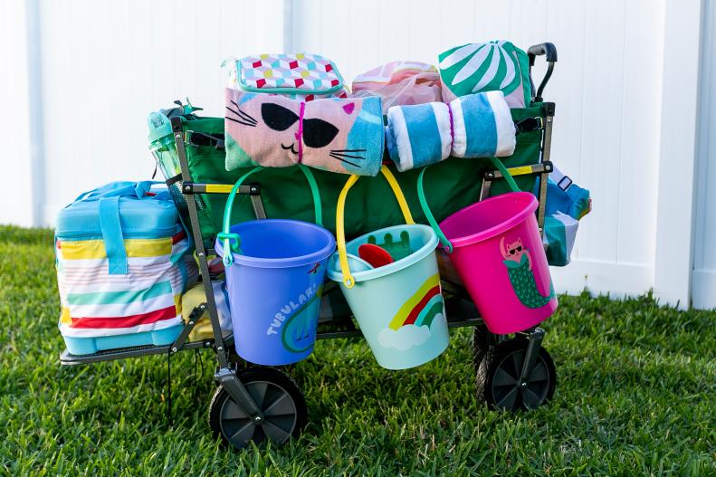 A utility wagon packed for the beach with towels, coolers, pails and shovels.