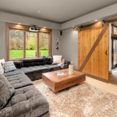 Media Room With Rustic Barn Door and Gray Sectional Sofa