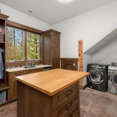Laundry Room With Folding Island and Wood Cabinetry