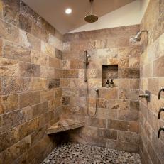 Luxury Shower With Stone Walls and Mosaic Tile Floor