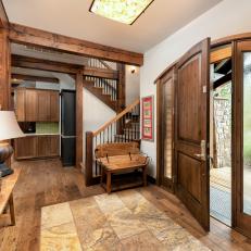 Open Foyer With Arched Wooden Front Door