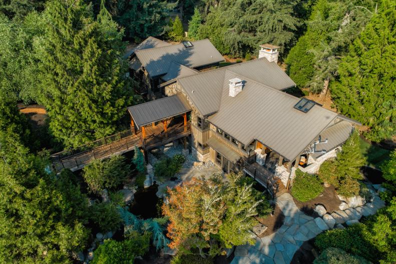 Overhead View of Mansion With Covered Bridge Nestled in Forest