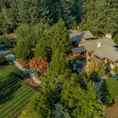Overhead View of Forest Mansion With Manicured Lawn