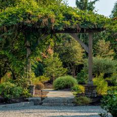 Wooden Arch Over Walkway Through Landscaped Area