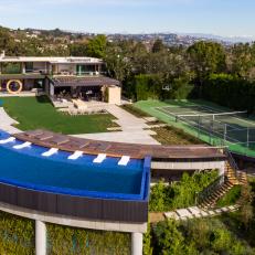 Elevated View of Contemporary Estate With Curved Pool and Tennis Court