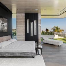 Retractable Doors Open Neutral Contemporary Bedroom Onto Backyard