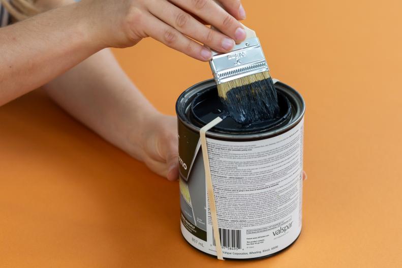 A Rubber Band Is Wrapped Around a Can of Black Paint