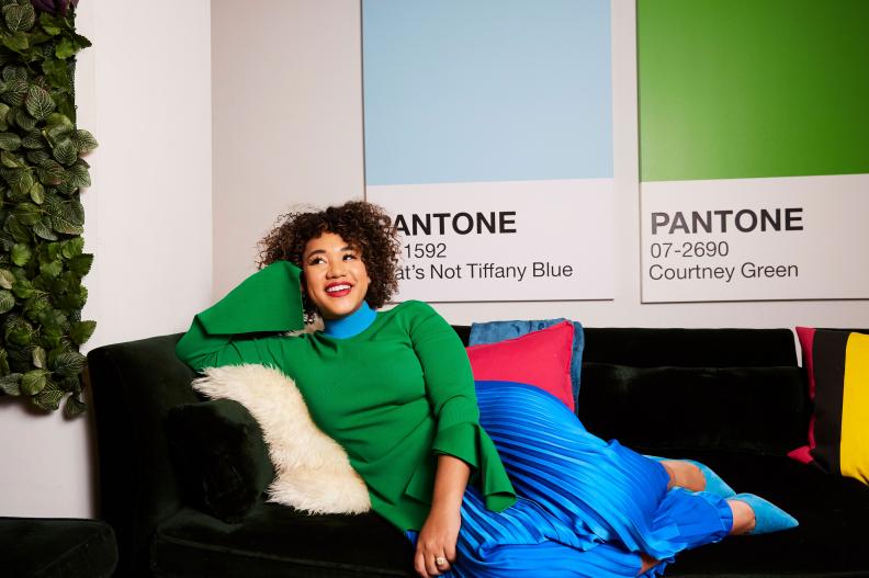 Courtney Quinn Sits on a Sofa Filled with Colorful Throw Pillows
